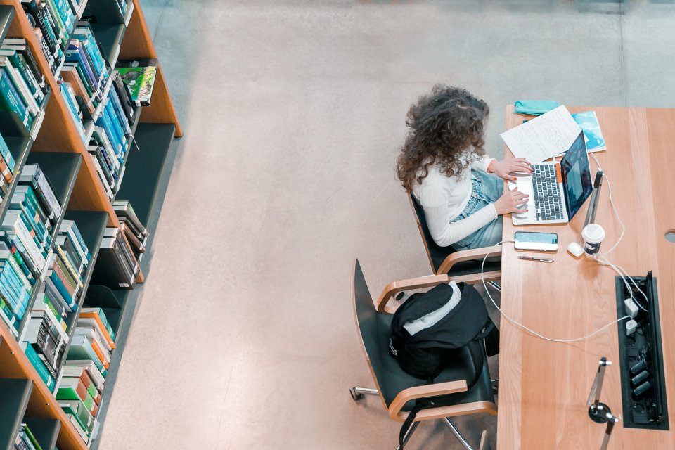 Studente strādā pie datora LU Akadēmiskā centra Dabas mājas bibliotēkā. null