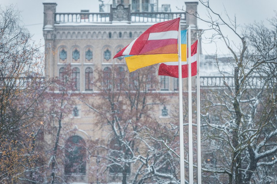Latvijas un Ukrainas karogi uz Latvijas Universitātes galvenās ēkas fona. null