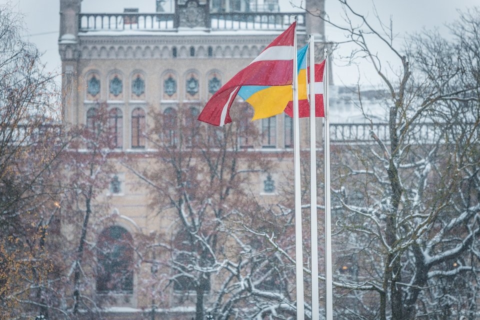 Latvijas un Ukrainas karogi uz Latvijas Universitātes galvenās ēkas fona. null