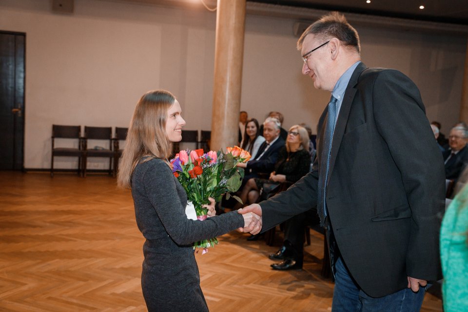 Latvijas Universitātes darbinieku kopsapulce. LU Gada balvas par izcilu promocijas darbu ieguvēju Ingu Pudžu sveic LU Fizikas, matemātikas un optometrijas fakultātes dekāns asoc. prof. Sandris Lācis.